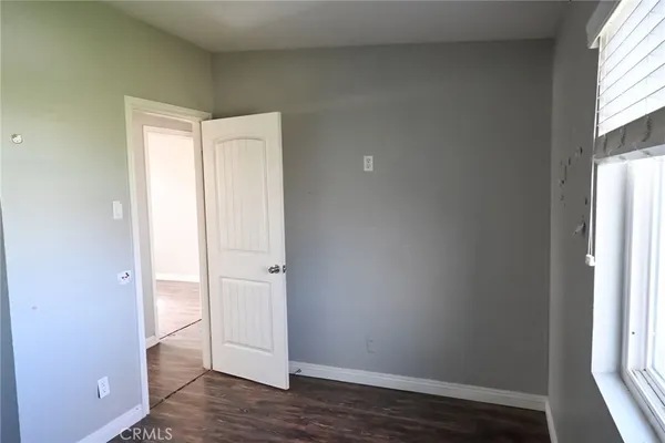 an empty room with wooden floor and window