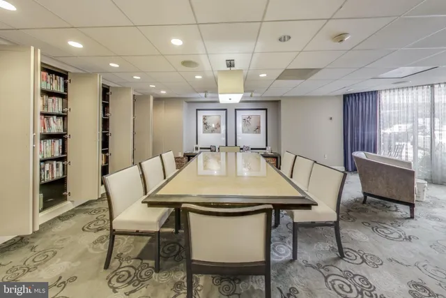 a living room with furniture a table and kitchen view