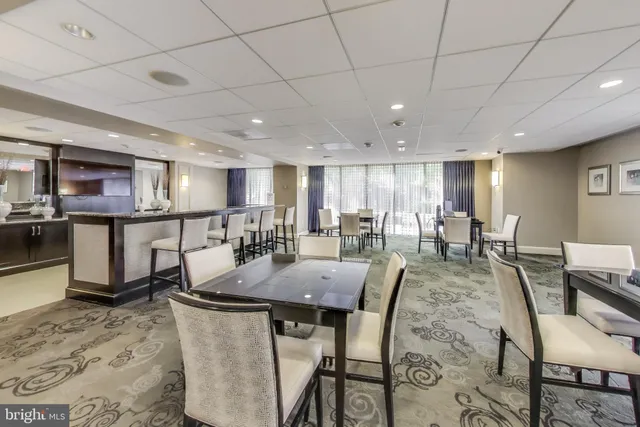 a large kitchen with a large counter top a sink a counter space and stainless steel appliances