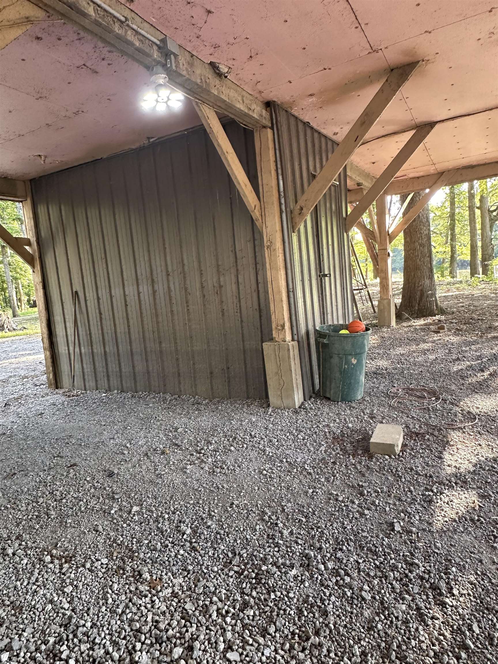 481 Chisholm Lake Camp Road Ripley, TN 38063 - Photo 3 of 12 Sheltered outdoor area featuring a gravel surface, exposed wood structural beams, and a corrugated metal wall