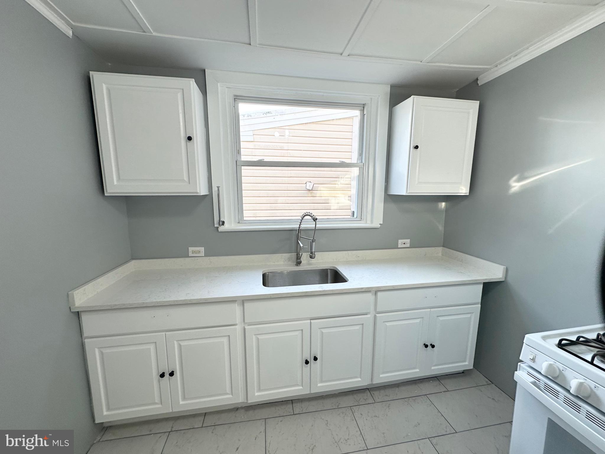 331 Tyler Street Trenton, NJ 08609 - Photo 15 of 49 a kitchen with white cabinets and a sink