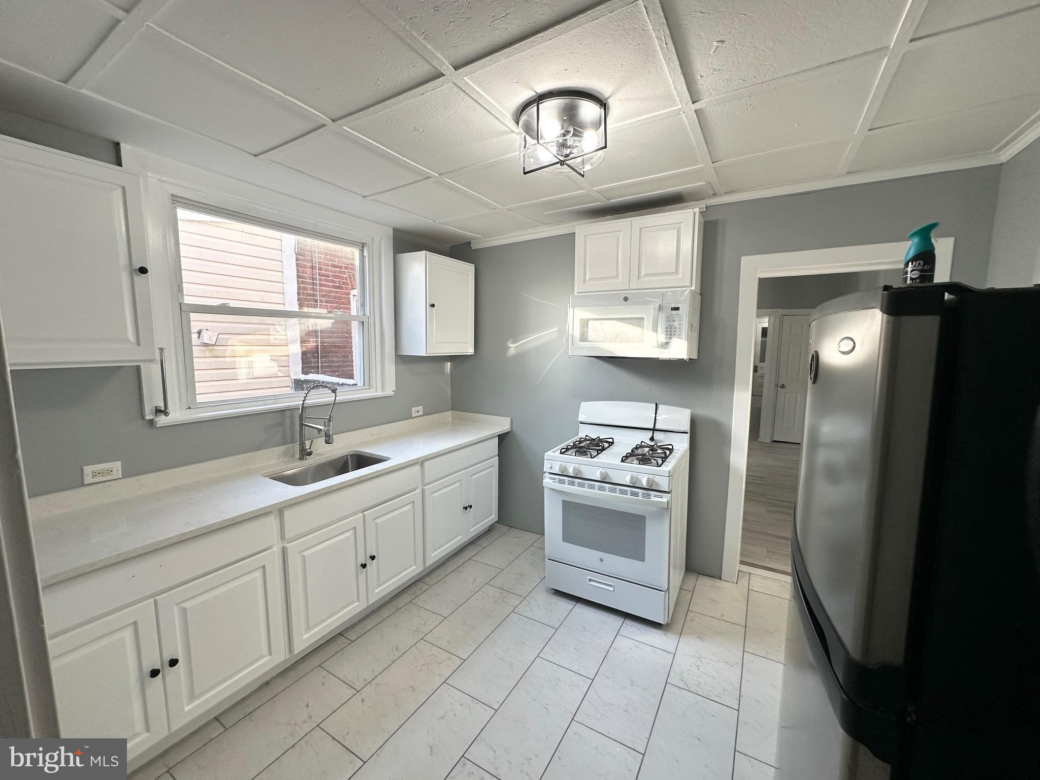 331 Tyler Street Trenton, NJ 08609 - Photo 16 of 49 a kitchen with cabinets appliances and a window