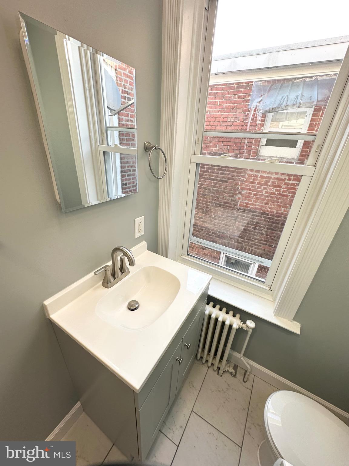 331 Tyler Street Trenton, NJ 08609 - Photo 28 of 49 a bathroom with a sink a mirror and a toilet