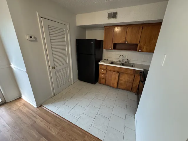 a kitchen with granite countertop a refrigerator and a sink