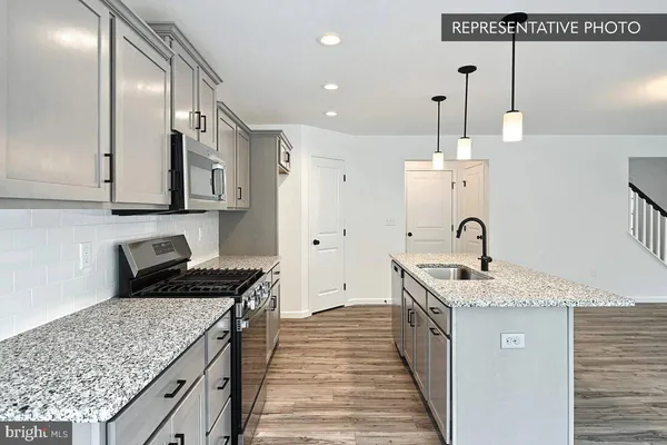 a kitchen with stainless steel appliances granite countertop a sink stove and cabinets