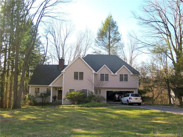 a view of a house with a big yard and large trees