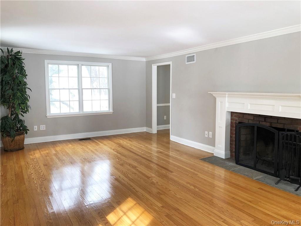 49 Commodore Road Chappaqua, NY 10514 - Photo 11 of 26 an empty room with wooden floor fireplace and windows