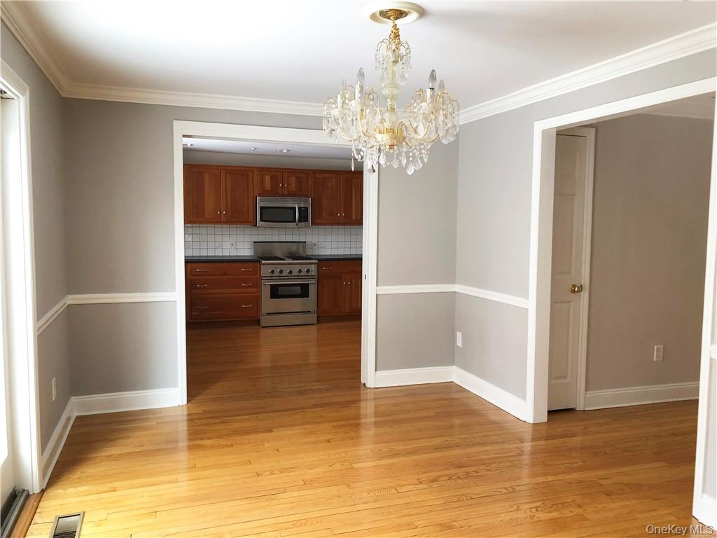 49 Commodore Road Chappaqua, NY 10514 - Photo 13 of 26 a view of a hallway with wooden floor and a kitchen