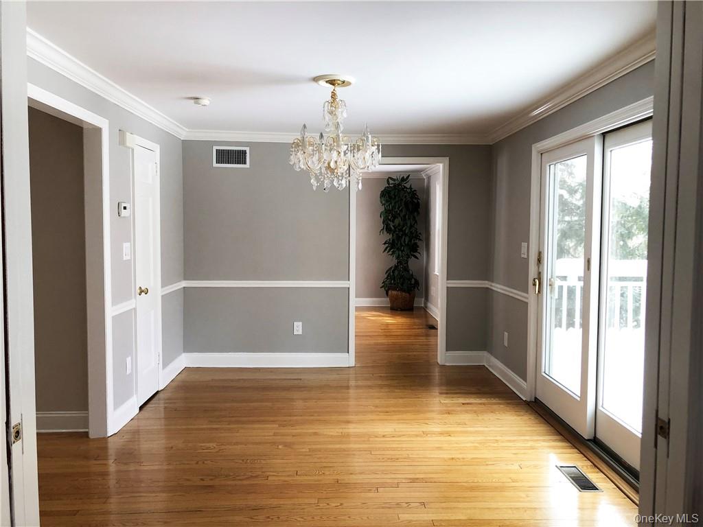 49 Commodore Road Chappaqua, NY 10514 - Photo 14 of 26 a view of a hallway with wooden floor and a dining room
