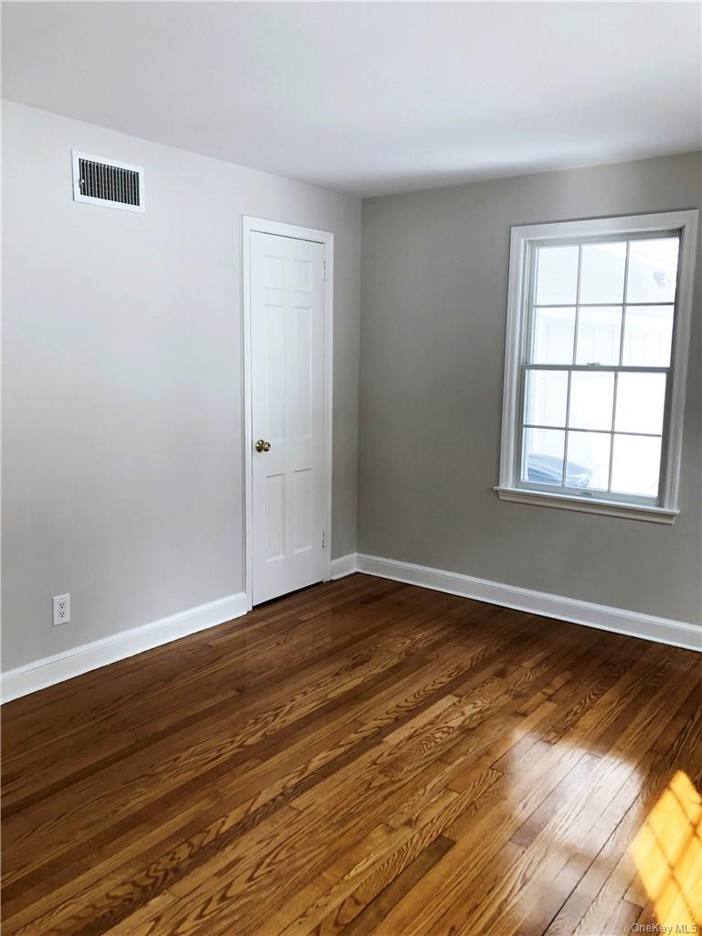 49 Commodore Road Chappaqua, NY 10514 - Photo 16 of 26 a view of an empty room with wooden floor and a window
