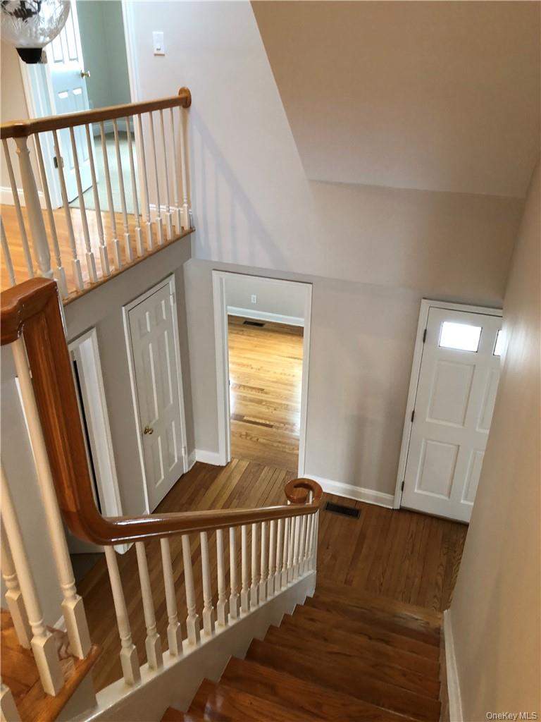 49 Commodore Road Chappaqua, NY 10514 - Photo 7 of 26 a view of a hallway with wooden floor and staircase