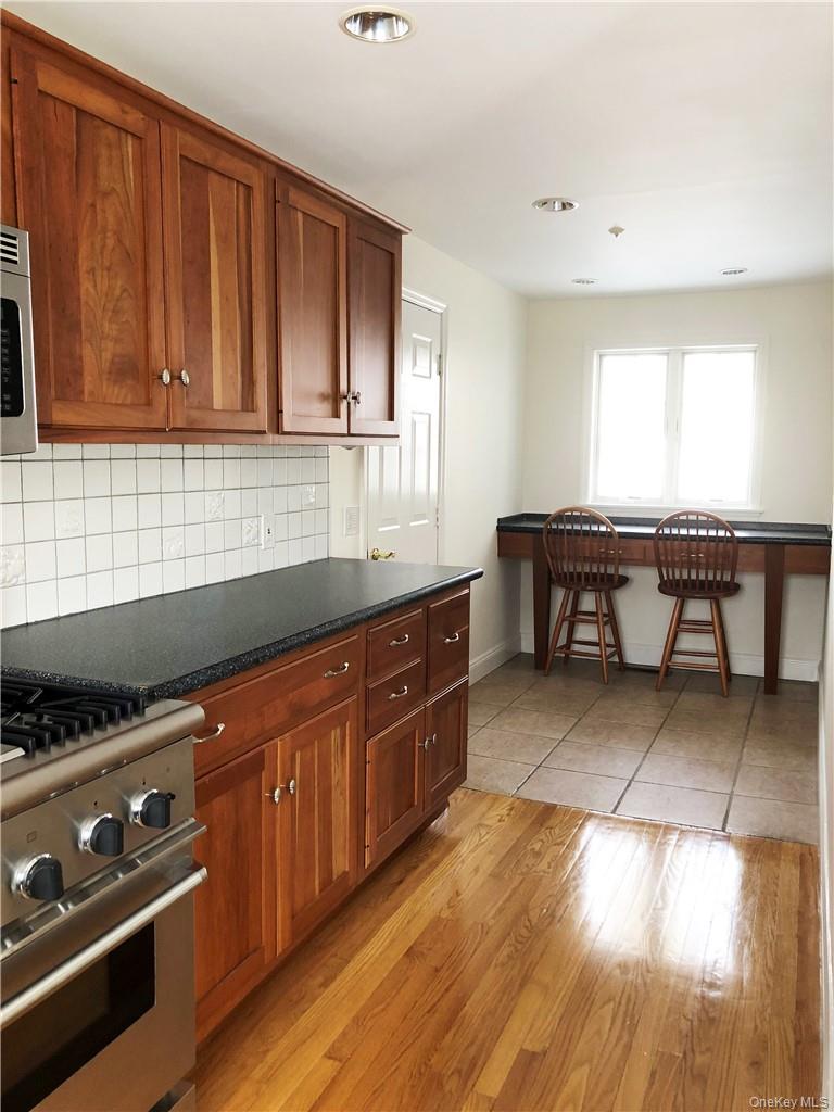 49 Commodore Road Chappaqua, NY 10514 - Photo 10 of 26 a kitchen with stainless steel appliances granite countertop a stove a sink and a microwave