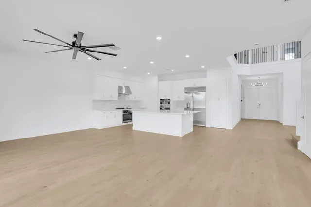 a view of a kitchen with wooden floor and a ceiling fan
