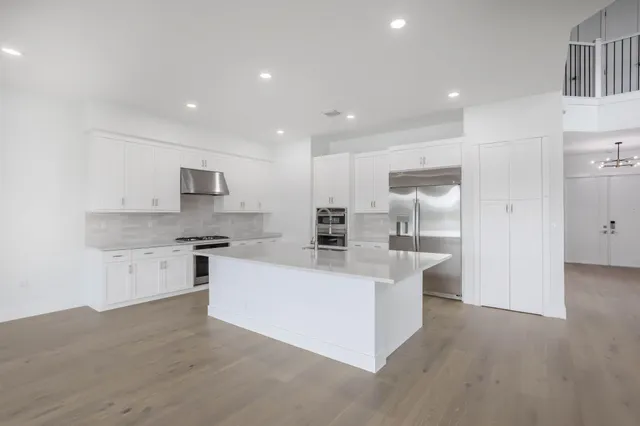 a large white kitchen with stainless steel appliances