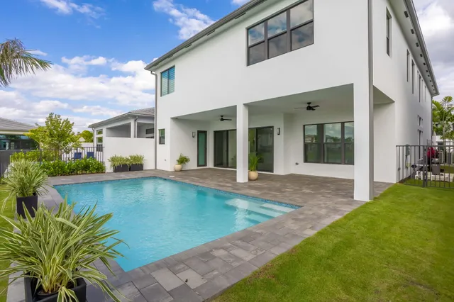 a view of a house with backyard and sitting area