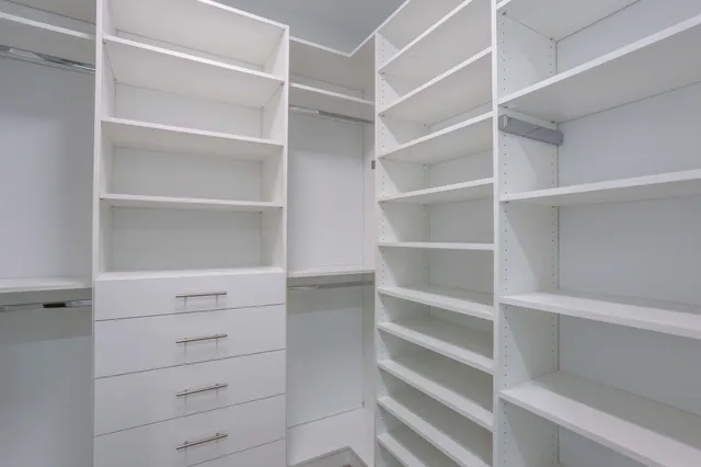 an empty room with a ceiling fan and carpet