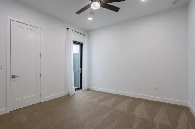 an empty room with a window and ceiling fan