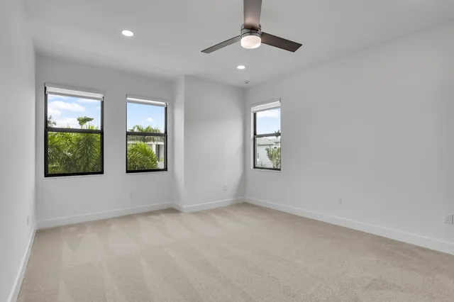 an empty room with a window and ceiling fan