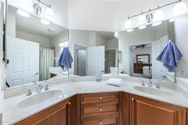 a bathroom with a sink a toilet a mirror and shower