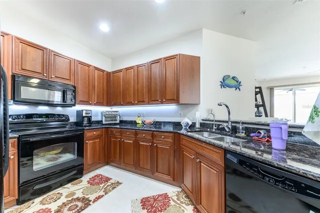 a kitchen with granite countertop stainless steel appliances and wooden cabinets