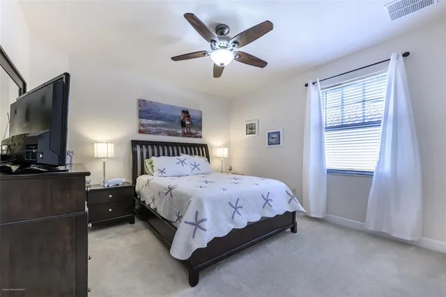 a bedroom with a bed and a flat tv screen on dresser