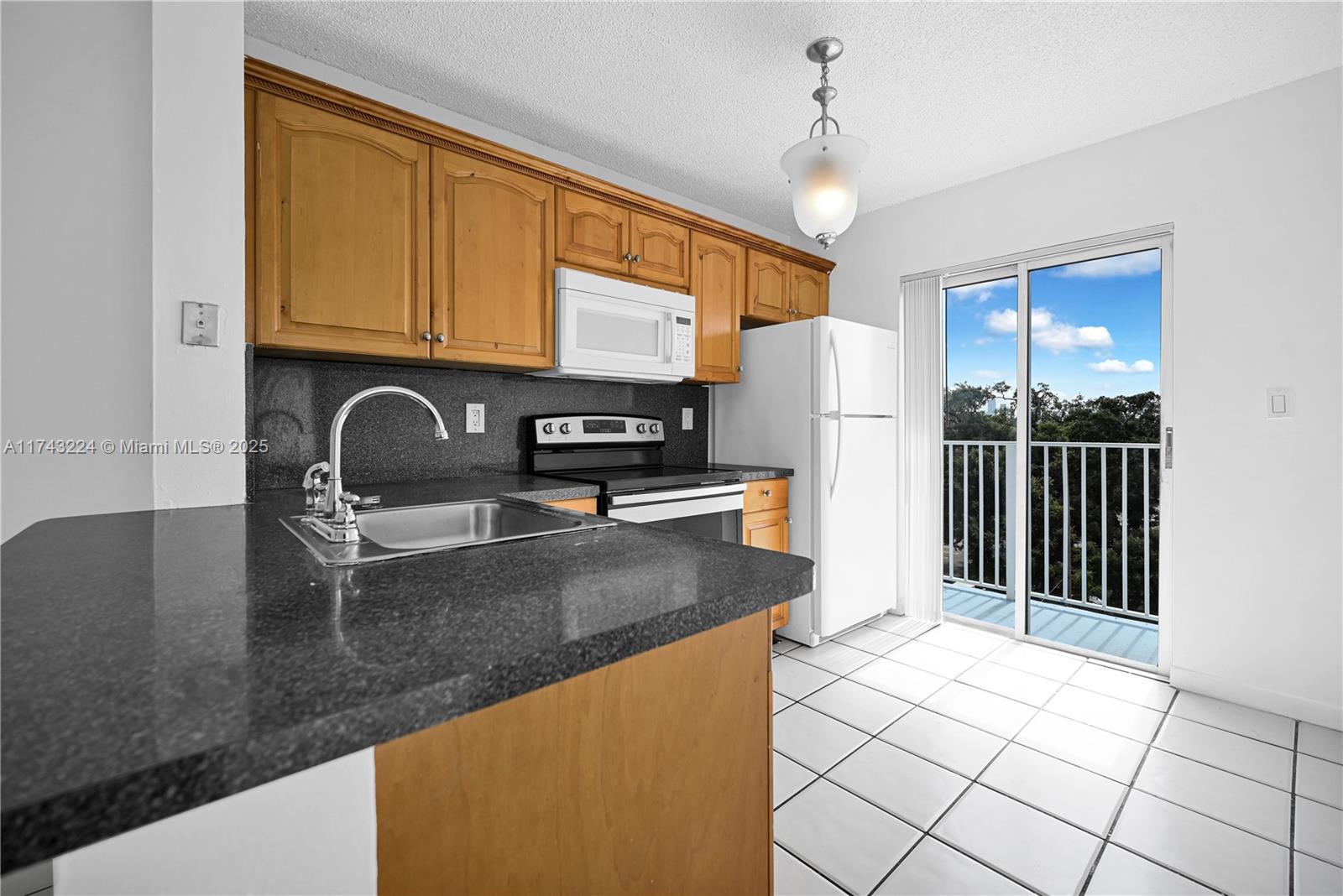 2575 Southwest 27th Avenue, Unit 508 Miami, FL 33133 - Photo 7 of 15 a kitchen with stainless steel appliances granite countertop a sink refrigerator stove and microwave