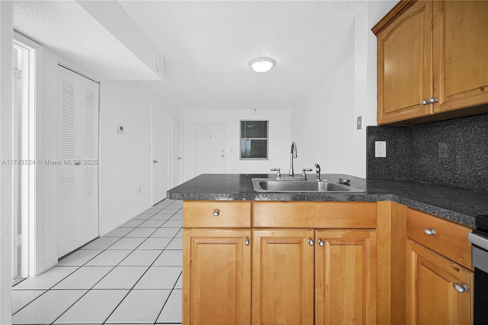 2575 Southwest 27th Avenue, Unit 508 Miami, FL 33133 - Photo 8 of 15 a room with granite countertop a sink a stove and cabinets