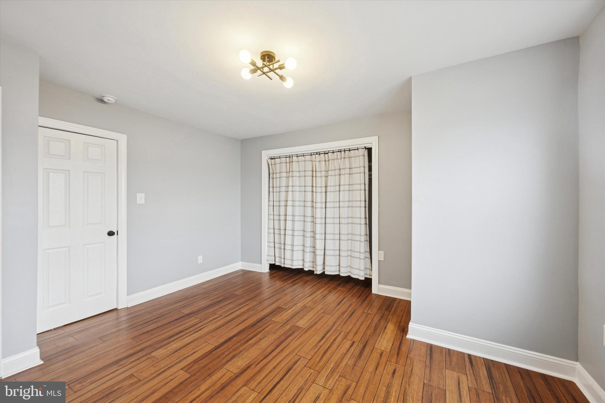7046 Radbourne Road Upper Darby, PA 19082 - Photo 11 of 14 a view of an empty room with wooden floor and a window