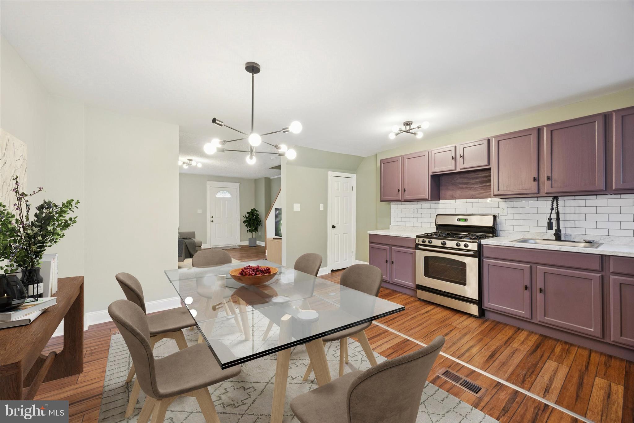 7046 Radbourne Road Upper Darby, PA 19082 - Photo 4 of 14 a kitchen with stainless steel appliances granite countertop a stove top oven a sink dishwasher and a dining table with wooden floor
