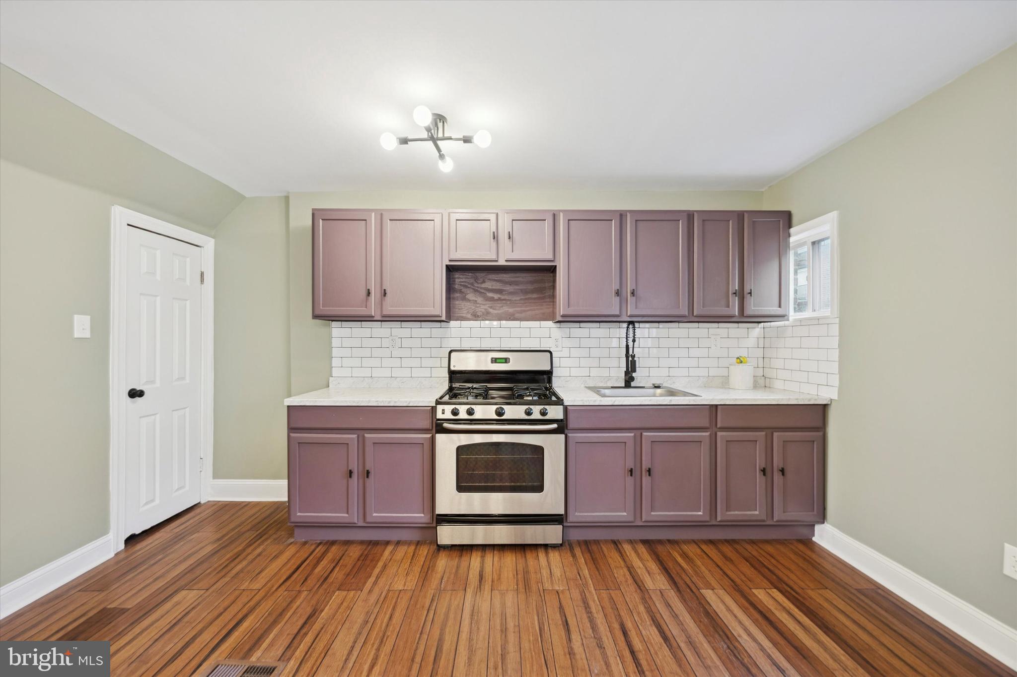 7046 Radbourne Road Upper Darby, PA 19082 - Photo 5 of 14 a kitchen with wooden floors appliances and cabinets