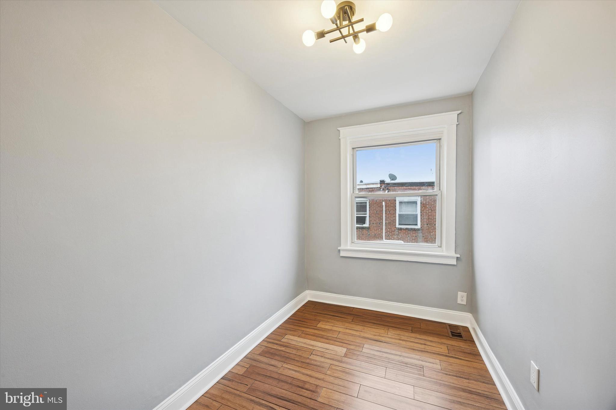 7046 Radbourne Road Upper Darby, PA 19082 - Photo 8 of 14 a view of an empty room with a window and wooden floor
