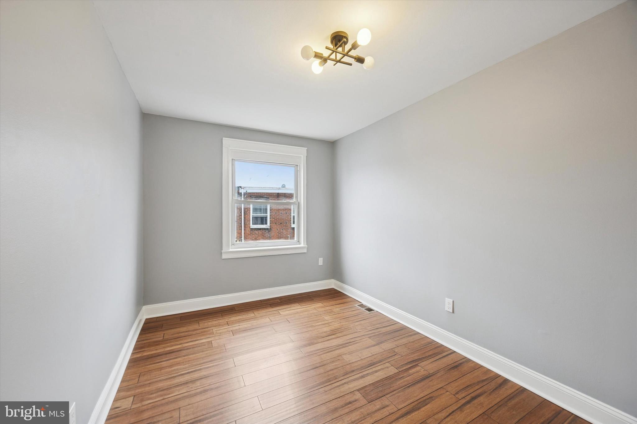 7046 Radbourne Road Upper Darby, PA 19082 - Photo 9 of 14 a view of an empty room with wooden floor and a window