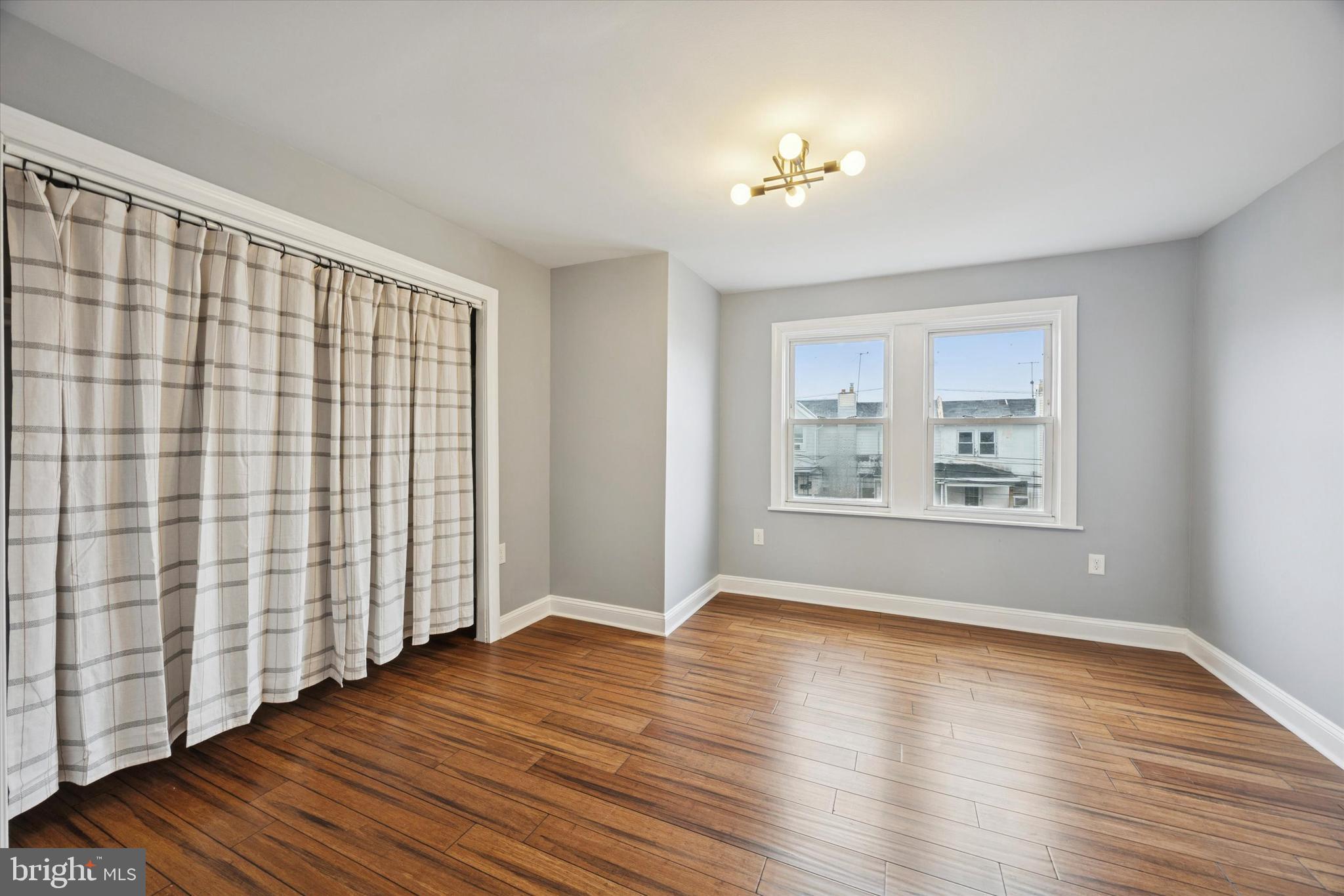 7046 Radbourne Road Upper Darby, PA 19082 - Photo 10 of 14 a view of an empty room with wooden floor and a window