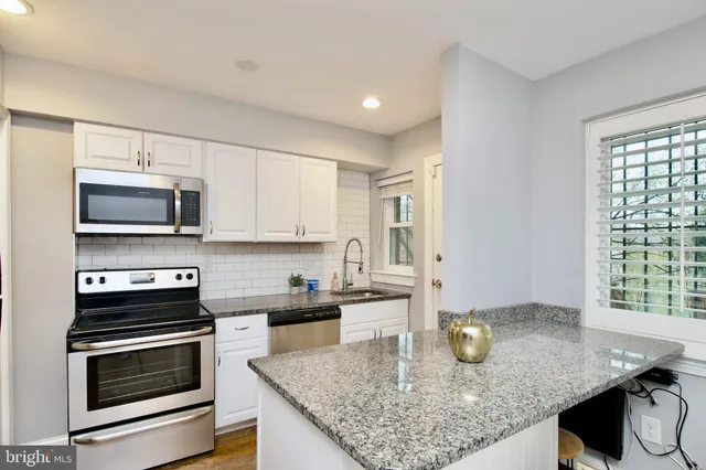 a kitchen with stainless steel appliances granite countertop a stove top oven a sink and dishwasher