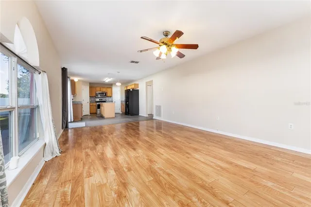 an empty room with windows and fan