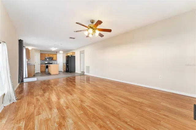 an empty room with windows and fan