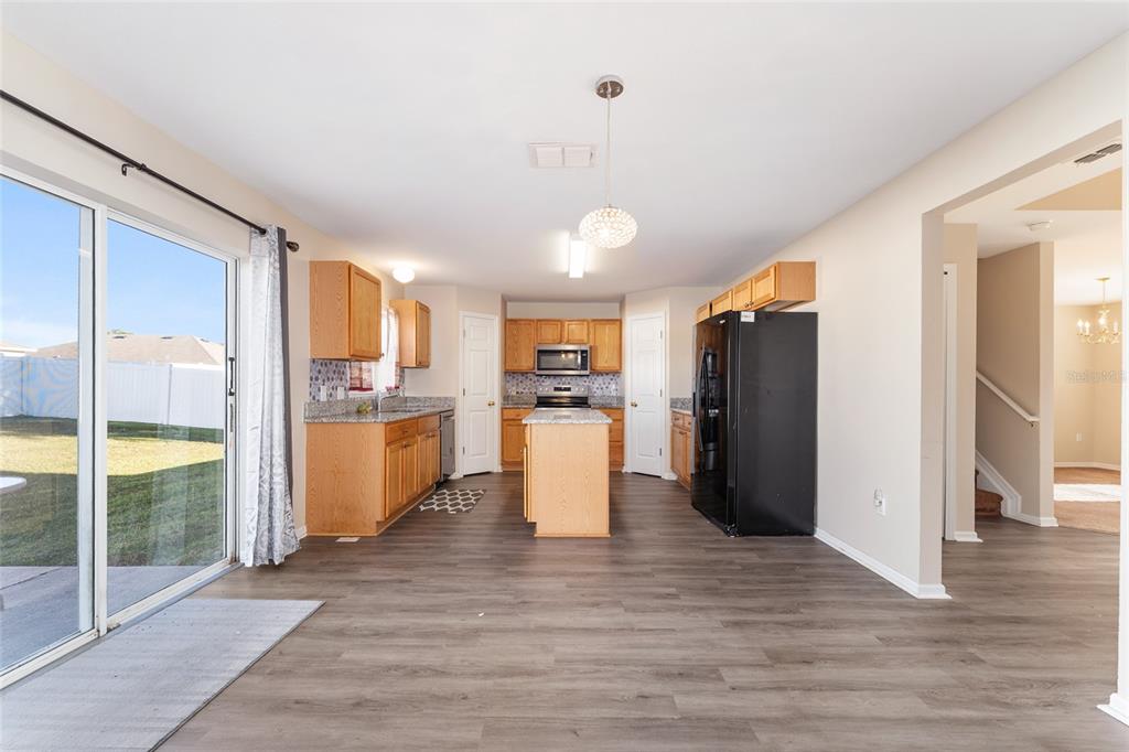 2661 Northeast 42nd Road Ocala, FL 34470 - Photo 25 of 74 a view of a kitchen with refrigerator and wooden floor