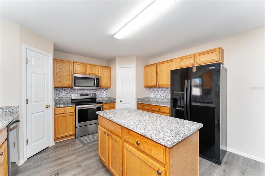 2661 Northeast 42nd Road Ocala, FL 34470 - Photo 30 of 74 a kitchen with stainless steel appliances granite countertop a refrigerator a stove top oven a sink and dishwasher