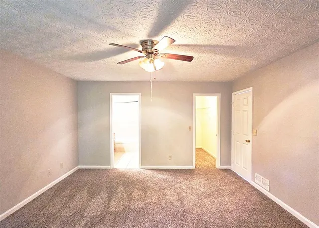 a view of a big room with chandelier fan and windows