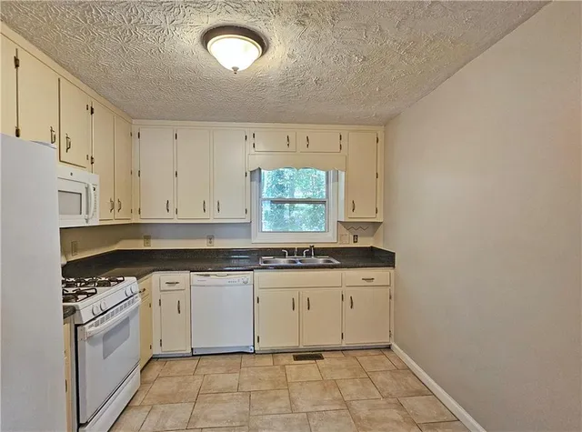 a kitchen with a stove a sink and a refrigerator