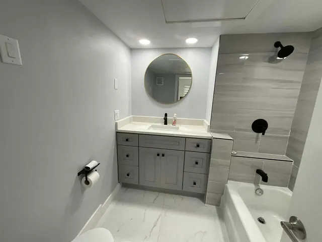 a bathroom with a double vanity sink toilet mirror and bathtub