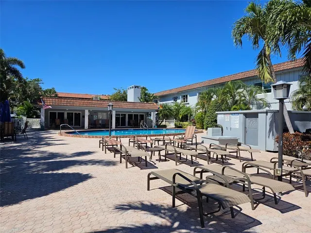 a view of patio with chairs and table under an umbrella