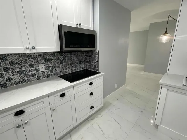 a kitchen with white cabinets and a stove