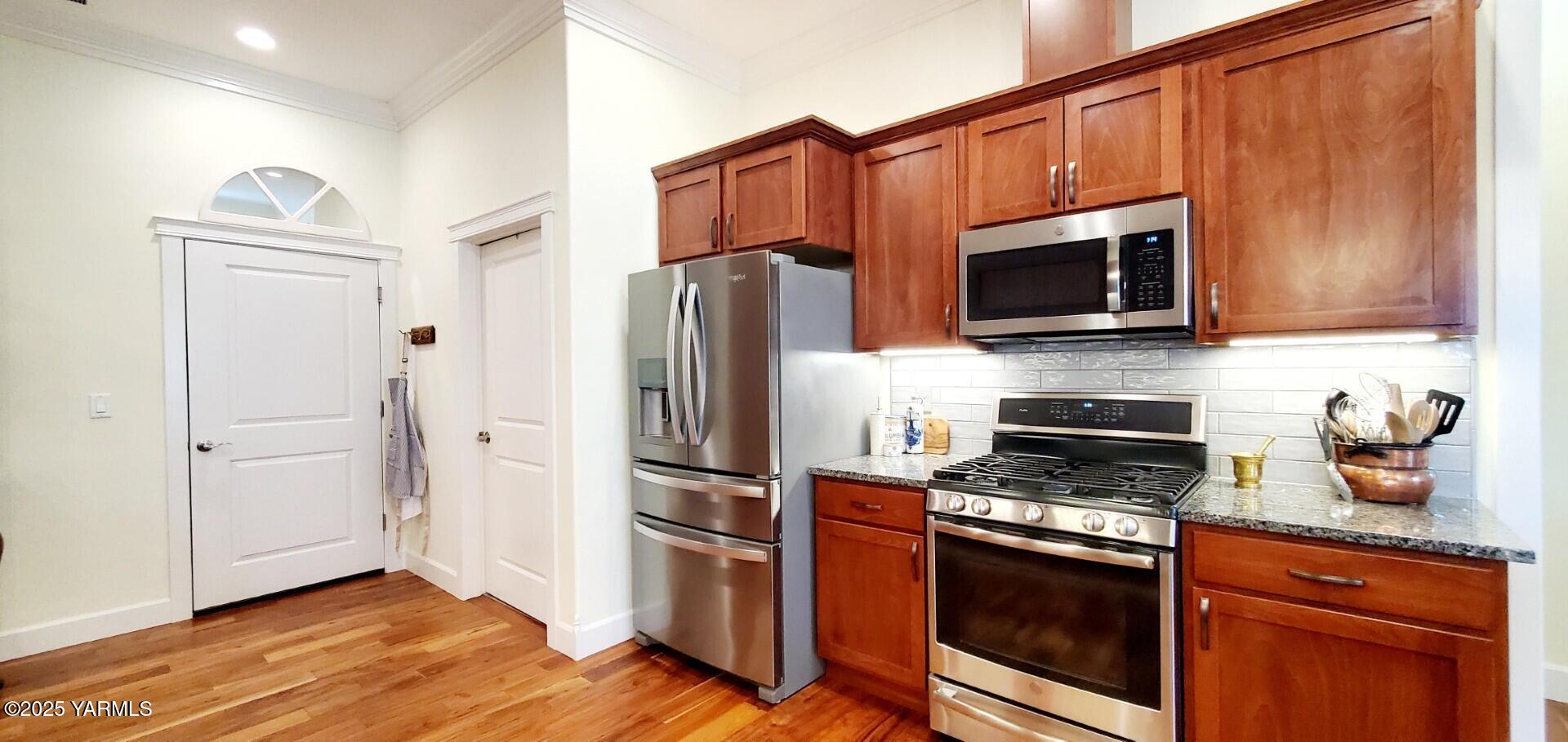 7106 Vista Ridge Avenue Yakima, WA 98903 - Photo 12 of 43 a kitchen with granite countertop a refrigerator stove and microwave
