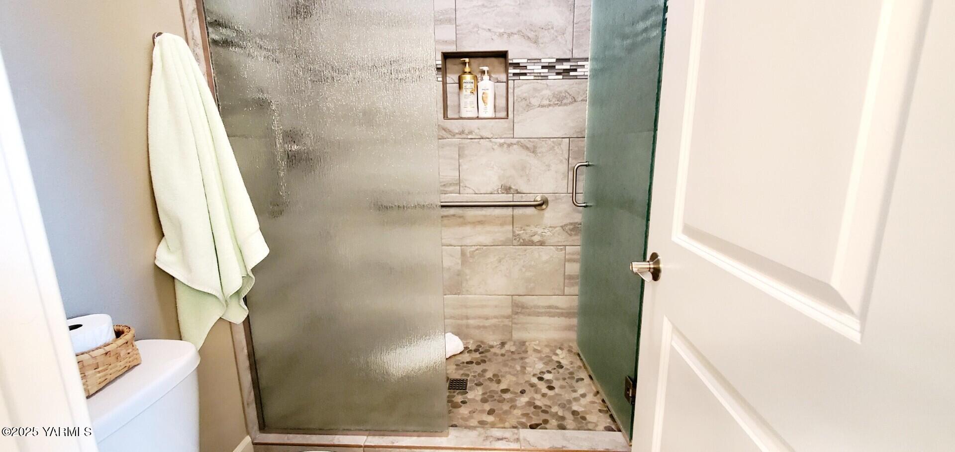 7106 Vista Ridge Avenue Yakima, WA 98903 - Photo 29 of 43 a bathroom with a glass shower door