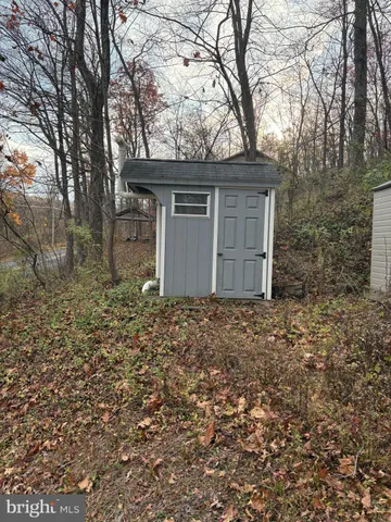 a house is sitting in middle of the forest