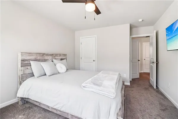 a bed room with a bed and a ceiling fan