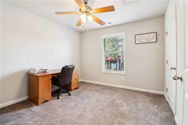 a view of a workspace with furniture and a window