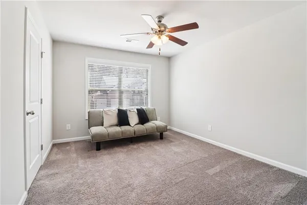 an empty room with windows and ceiling fan