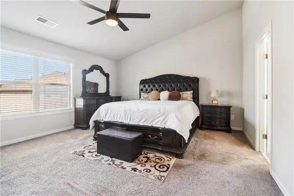 a spacious bedroom with a bed and wooden floor